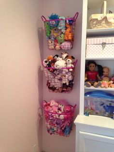 there are many toys in baskets on the shelf next to the toy bins and bookshelves