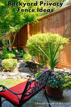 backyard privacy fence ideas with red bench in the foreground and green trees on either side