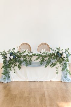 the table is covered with greenery and candles for an elegant touch to the space