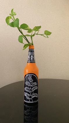 a bottle with a plant in it sitting on a table