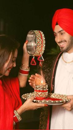 a man and woman are holding a cake