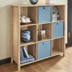 a wooden shelf with blue bins on top of it and bookshelf below