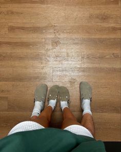 a person standing on top of a wooden floor with their feet up in the air