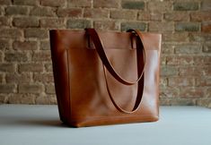 Tan / Cognac Leather tote bag with large outside pocket. Cognac Cap Sa Sal Bag. Handmade. Classic Tote Bag With Pockets, Classic Tote Satchel With Pockets, Everyday Brandy Rectangular Bag, Brandy Rectangular Bag For Everyday Use, Brandy Rectangular Bags For Everyday Use, Leather Work Bag, Large Leather Bag, Genuine Leather Totes, Veg Tan Leather