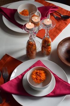 the table is set with plates, silverware and orange napkins for dinner guests to enjoy