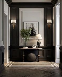 the hallway is decorated in black and white with an elegant table, lamps, and artwork