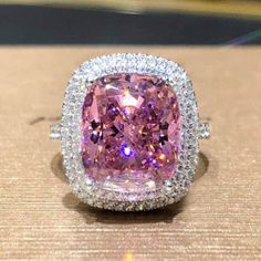 a fancy pink diamond ring with diamonds around it