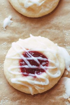 two cookies with white icing and jelly on them