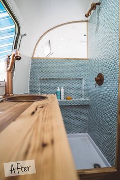 a bathroom with blue and white tiles on the walls, wood counter top and sink