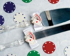 a pair of scissors sitting on top of a table next to poker chips and playing cards