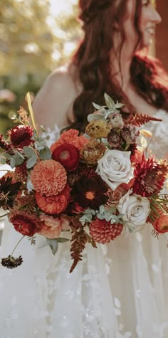 a woman holding a bouquet of flowers in her hands