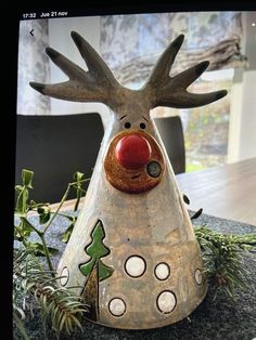 a christmas decoration with a reindeer head and red nose on top of a granite table