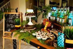 a table topped with lots of cakes and desserts next to a sign that says happy birthday