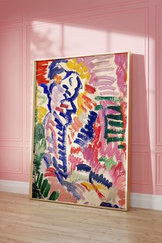 an abstract painting is displayed in front of a pink wall and wooden floor with light coming through the window