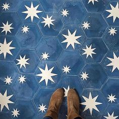 a person standing in front of a blue and white tile floor with stars on it