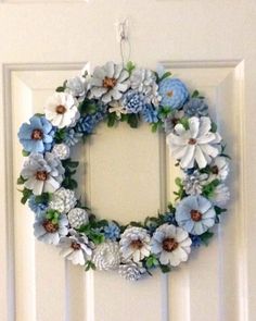 a white door with a blue and white wreath hanging on it's front door