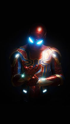 an iron man standing in the dark with his arms crossed and glowing from behind him