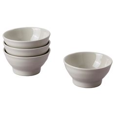 four white bowls sitting next to each other on top of a white tableware set