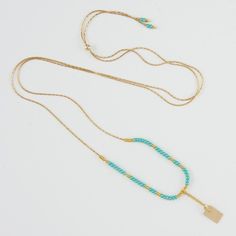 Close-up of delicate gold necklace with turquoise and gold beads and gold rectangle drop pendant. Elegant Turquoise Beaded Chain, Elegant Turquoise Beaded Necklace Hand-strung, Adjustable Hand-strung Turquoise Necklace, Adjustable Turquoise Hand-strung Beaded Necklace, One-of-a-kind Gold Bohemian Turquoise Necklace, Hanging Pendants, White Beads, Gold Filled Chain, Beaded Chain