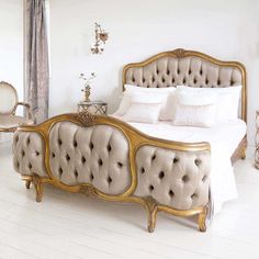 an ornately decorated bedroom with white walls and flooring, including a gold bed frame