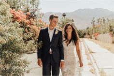 a man and woman are walking down the street holding each other's hand as they smile