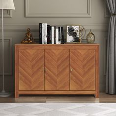 a wooden cabinet with books and other items on it next to a lamp in a room