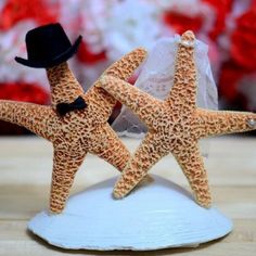 two starfish figurines in hats on a table