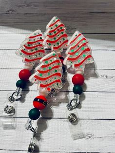 a red and green beaded christmas tree ornament on a white wooden background