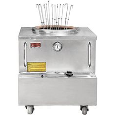 an electric fryer with tongs on the top and two forks sticking out of it