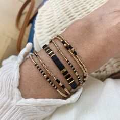 Beautiful set of two bracelets, a beaded strech wrap bracelet, wraps 5 times around your wrist, with champagne gold and black Japanese seed beads and a lovely adjustable Tila beaded bracelet with black and gold square flat beads on silk cord. This set is Lightweight and very comfortable to wear, the perfect summer stack! M A T E R I A L * Wrapbracelet: Seed beads from Miyuki (high quality seed beads from Japan) champagne gold, black and facet beads, very strong elastic * Tila bracelet: Silk cord Elegant Heishi Bead Bracelets With Tiny Beads, Elegant Gold Friendship Bracelets With Colorful Beads, Black Bracelets With Tiny Beads For Party, Elegant Adjustable Wrap Bracelet With Tiny Beads, Adjustable Multi-strand Beaded Bracelet With Gold Beads, Bohemian Gold Beaded Bracelets With Black Beads, Gold Friendship Bracelets With Colorful Beads For Parties, Adjustable Multi-strand Gold Beaded Bracelets, Bohemian Gold Bracelet With Black Beads