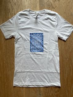 Design inspired by coral. Made using a hand carved linoleum block. Printed on 100% cotton medium weight tees. Print is 5 inches wide by 7 inches tall. 2 inch diameter logo printed on back right below neck. White Hand Printed Crew Neck T-shirt, Blue Organic Cotton Top With Screen Print, Blue Organic Cotton Graphic Tee, White Hand Printed Short Sleeve Tops, Hand Printed Crew Neck Graphic Tee, Hand Printed Graphic Tee With Crew Neck, Blue Organic Cotton T-shirt With Screen Print, White Hand Printed T-shirt For Summer, White Hand Printed Crew Neck Top