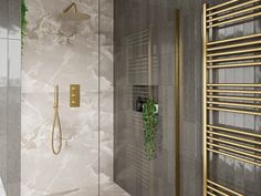 a bathroom with marble walls and flooring next to a gold towel rack on the wall