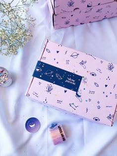 two pink boxes with space themed designs on them