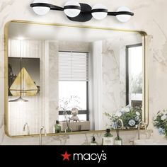 a bathroom mirror sitting above a sink under a faucet mounted on a wall