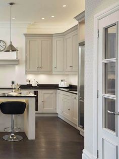 a kitchen with white cabinets and black counter tops, along with an island in the middle