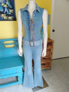 "Great condition retro denim jumpsuit, features zipper, suede lace upfront and belt with Metal Buckle. Flared pants. The label is 'Innocent' reads Medium however is a Small, the denim has about an 1\" stretch in fabric  Measurements: Shoulder Seams 4\" Neck 18\" round Collar 3\" wide Armholes 19\" clearance  Pocket 3.5\"wide x 4\" Deep Front Metal Zipper 17\" long Metal eyelets Suede Lace up Bust 32\"-34\" Waist 28\" Hips 34\" Belt 2.75\" wide, 45\" long Metal Buckle 3.5\" long, 2.5\" wide Crotc Fitted Denim Jumpsuit, Fitted Casual Belted Jeans, Casual Fitted Belted Jeans, Vintage Denim Fitted Jumpsuits And Rompers, Fitted Denim Vintage Jumpsuits And Rompers, Fitted Vintage Denim Jumpsuits And Rompers, Fitted Denim Jumpsuit With Belt, Fitted Belted Denim Jumpsuit, Vintage Fitted Denim Jumpsuit Overall