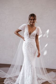 a woman in a white wedding dress with a veil on her head and wearing a bridal gown