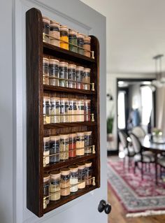 a wall mounted spice rack filled with lots of spices