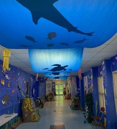 the hallway is decorated with blue walls and under - water decorations