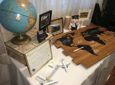 a table topped with an airplane and a wooden world map on it's side