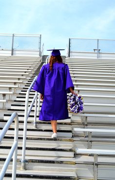 a woman in purple graduation gown walking up stairs