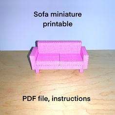 a pink couch sitting on top of a wooden table next to a white sign that says sofa miniatureture printable