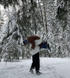 a person walking in the snow carrying something on his back with one hand and two other hands