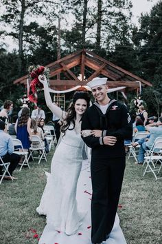 a man and woman are walking down the aisle after their wedding ceremony at an outdoor venue