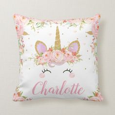 a white pillow with pink flowers and unicorns on it that says,'charlotte '