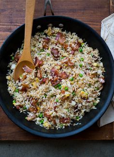 a skillet filled with rice, peas and bacon