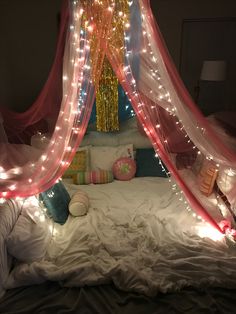 a bed with pink and white lights on the headboard, and canopy over it