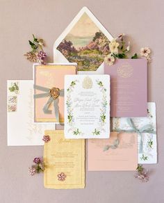 the wedding stationery is laid out on top of each other, including cards and envelopes