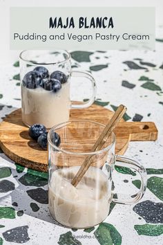 two glasses of pudding and vegan pastry cream on a wooden tray with blueberries