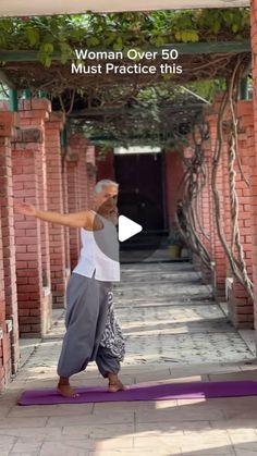 an older man is practicing yoga in front of a brick building with the words woman over 50 must practice this